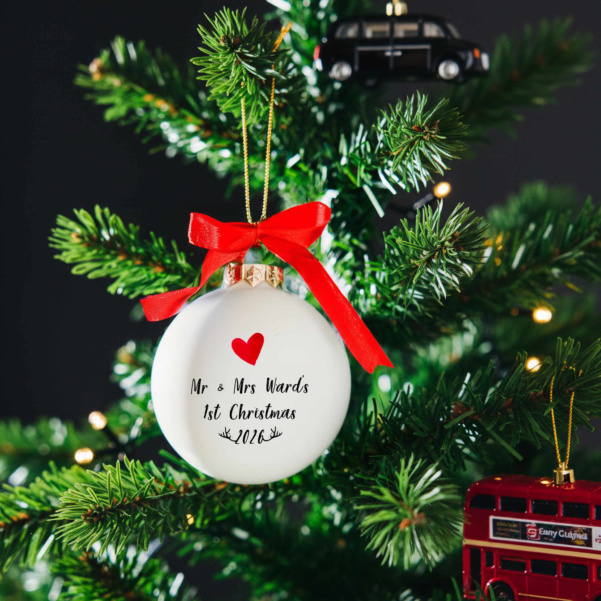 Personalised Mr & Mrs 1st Christmas white glass bauble hanging on a Christmas tree with red satin bow and gold cord – romantic gift for newlyweds