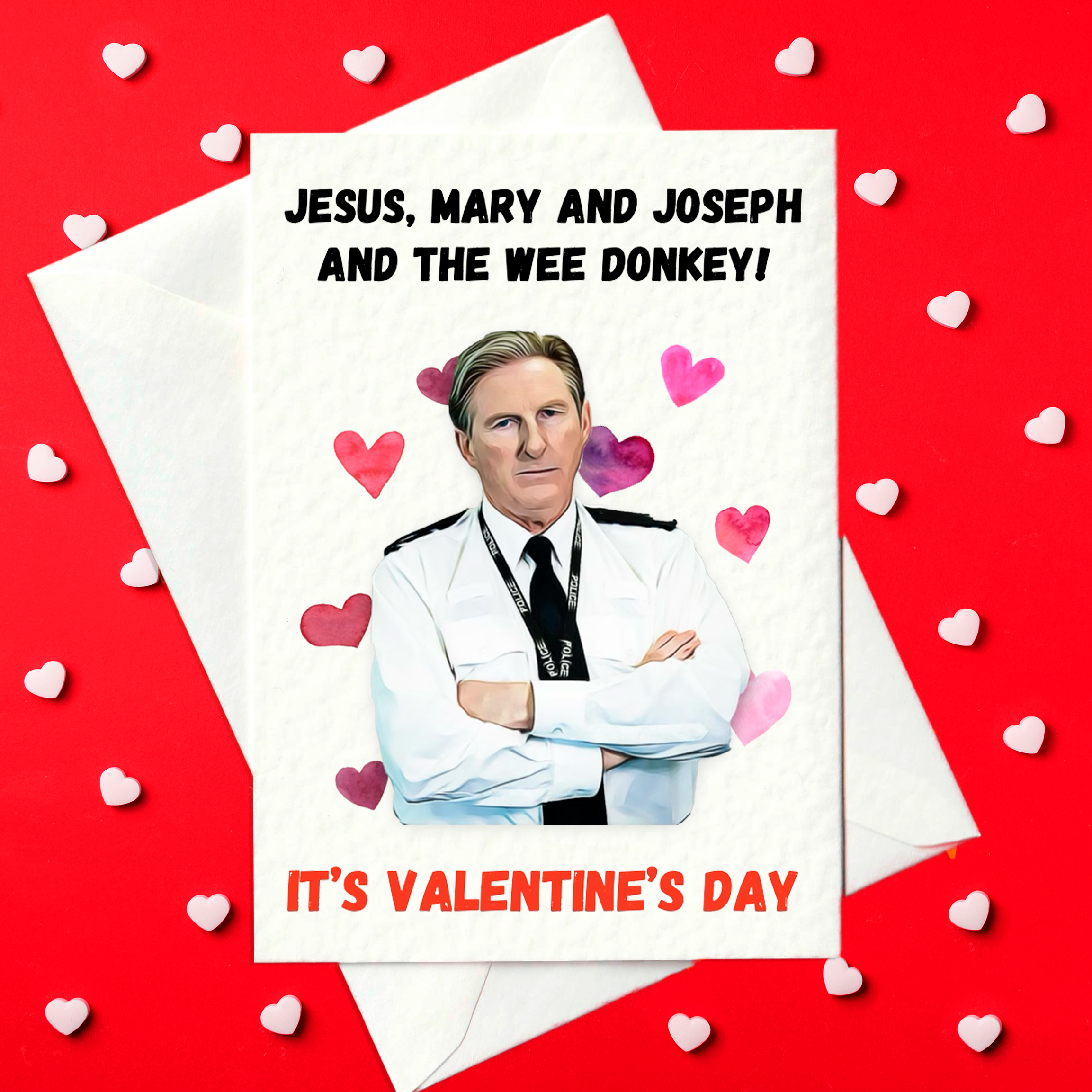 A6 Valentine’s card with the text “Jesus, Mary and Joseph and the wee donkey! It’s Valentine’s Day” above and below an illustration of a stern police officer, surrounded by pink hearts; blank inside with envelope.