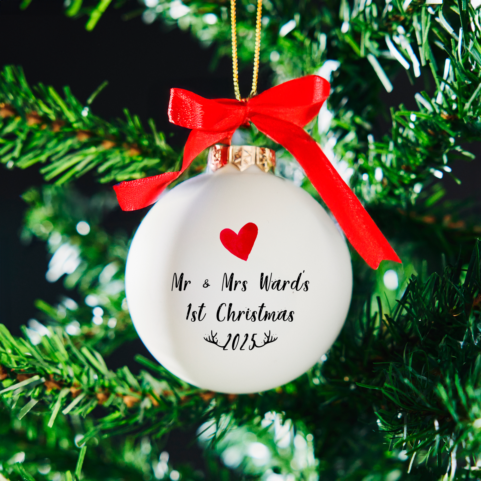 Personalised Mr & Mrs 1st Christmas white glass bauble hanging on a Christmas tree with red satin bow and gold cord – romantic gift for newlyweds